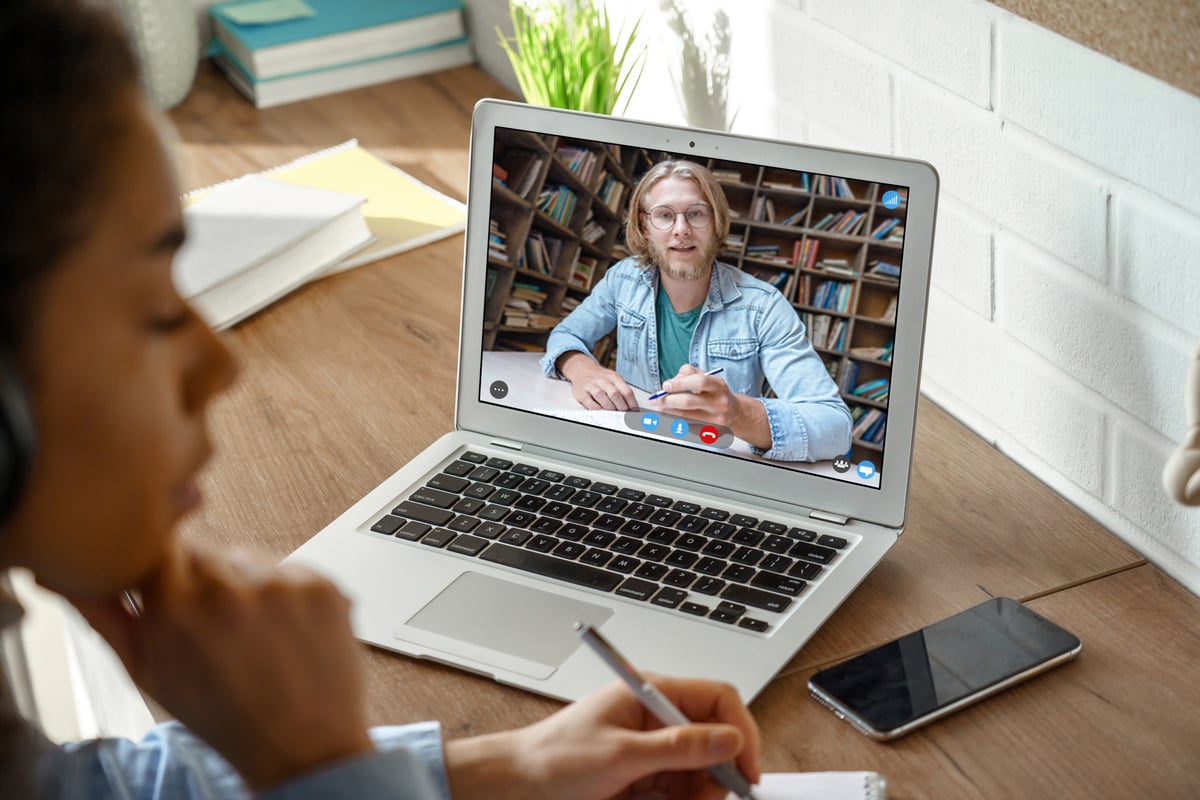 College Student Studying with Online Teacher on Laptop